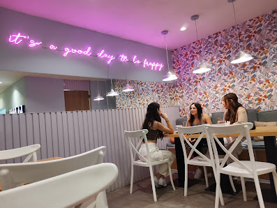 Interior de La Barrita con pared floral, tonos rosa y luces de neón